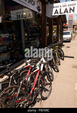 Fahrräder standen vor Alan Bike & Ski Shop mit Tankstelle im Hintergrund in Morzine Haute-Savoie Portes du Soleil Frankreich Stockfoto