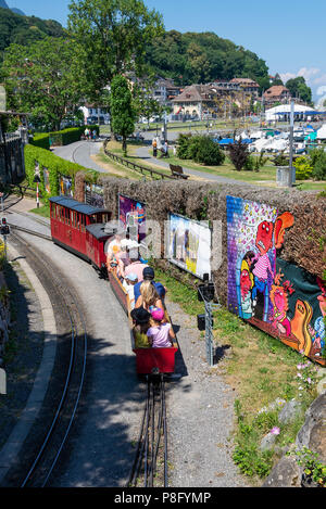 Ein Miniatur elektrische Pkw Motor und Zug auf der Strecke in der Swiss Vapeur Parc Bahn Attraktion in Le Bouveret Genfersee, Schweiz Stockfoto