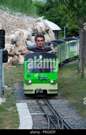 Ein funktionierendes Modell elektrische Zug mit Fahrgäste und Fahrer im Swiss Vapeur Parc Miniatur-eisenbahn Le Bouveret Genfersee, Schweiz Stockfoto