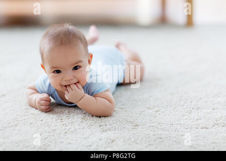 Süße kleine asiatische baby boy liegend auf dem Boden Stockfoto