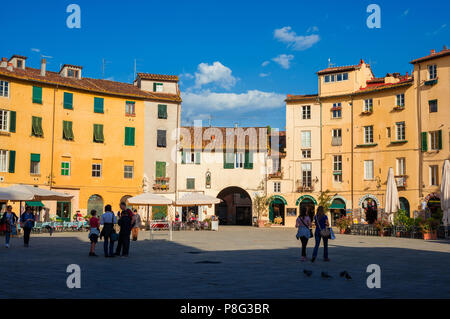 Der berühmten Piazza dell'Anfiteatro (Amphitheater Platz) im historischen Zentrum von Lucca, mit Häusern, die über antike römische Arena Ruinen erbaut Stockfoto