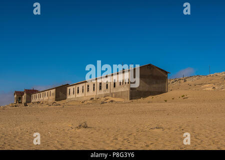 Reihe von verlassenen Gebäuden in Ghost Town von ehemaligen Diamond mining Gemeinschaft von Kolmanskop, die in der Nähe von Lüderitz in der Namib Wüste von Namibia Stockfoto