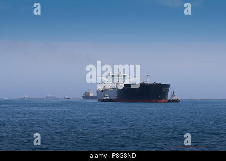 Foss Maritime Schleppschiffen führt den riesigen Supertanker, ALASKAN NAVIGATOR, wie es in den Hafen von Long Beach, Kalifornien, USA. Stockfoto