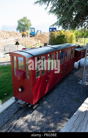 Ein Miniatur elektrische Pkw Motor und Zug auf der Strecke in der Swiss Vapeur Parc Bahn Attraktion in Le Bouveret Genfersee, Schweiz Stockfoto