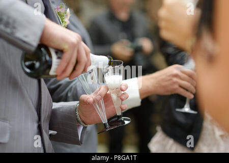 Eingießen in ein Glas Champagner auf einer Hochzeitsfeier Stockfoto
