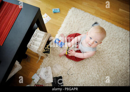 Adorable Baby Mädchen, ein Chaos zu Hause Stockfoto