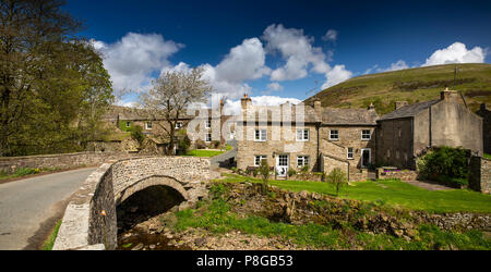 Das VEREINIGTE KÖNIGREICH, England, Yorkshire, Swaledale, Thwaite, Häuser des Dorfes über Brücke über Stroh Beck, Panoramablick Stockfoto