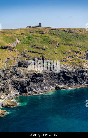 Blick über die Küste von Cornwall Tintagel Insel Halbinsel an der South West Coast Path und die St. Materiana Kirche in North Cornwall, England, Großbritannien Stockfoto