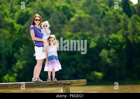 Junge Mutter und ihre beiden kleinen Töchter im Sommer Stockfoto