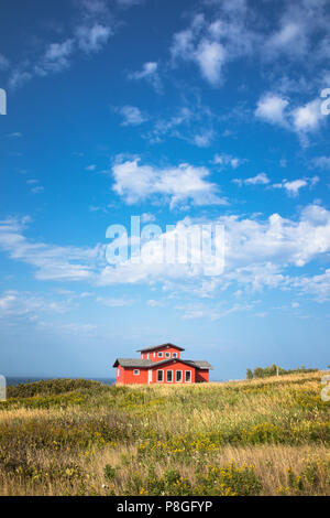 Ein bunt bemalten Holz- Haus von Havre Aubert, mit Sommer Himmel und das Meer in der Ferne. Iles de la Madeleine, Quebec, Kanada. Stockfoto