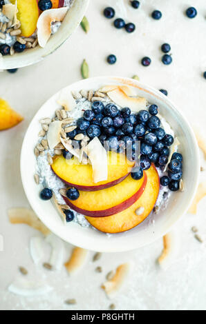 Chia Pudding mit Nektarinen, Blaubeeren, und Kokosraspeln. Stockfoto