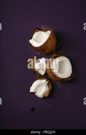 Risse coconut auf dunklem lila Hintergrund angeordnet Stockfoto