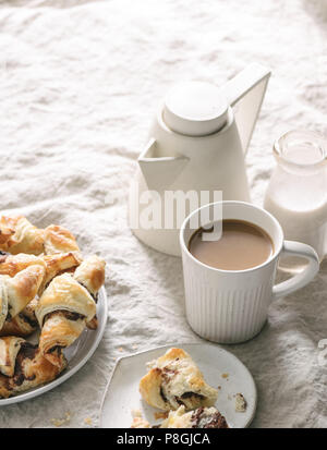 Schokolade, Croissants und Kaffee im Bett serviert. Stockfoto