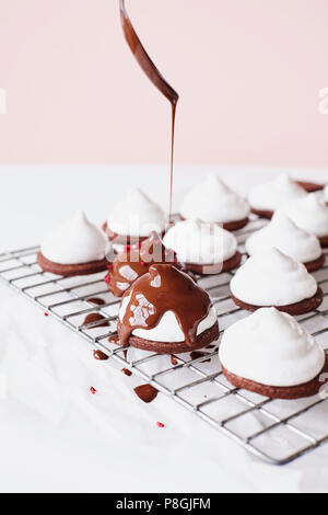 Nieselregen geschmolzene Schokolade auf Marshmallow Teacakes Stockfoto