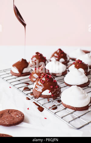 Nieselregen geschmolzene Schokolade auf Marshmallow Teacakes Stockfoto