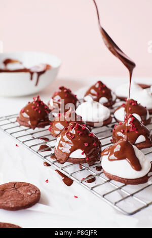 Nieselregen geschmolzene Schokolade auf Marshmallow Teacakes Stockfoto