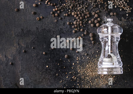 Vielzahl von verschiedenen schwarzen Pfeffer Piment, Pfeffer, Langer Pfeffer, Mönche Pfeffer, Pfefferkörner und Boden Pulver von transparent Pfeffer Mühle auf alten b Stockfoto