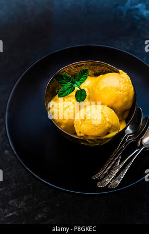Mango Eis serviert auf einer schwarzen Platte Stockfoto