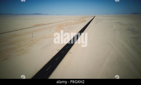 Lange Gerade tar Straße durch eine sehr trockene Wüste in Namibia. Stockfoto