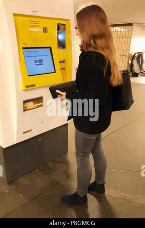 Berlin, Deutschland, junge Frau kauft ein Ticket am Automaten der BVG Stockfoto