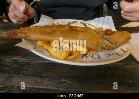 Platte von Panierten Fisch und Chips mit Erbsenpüree und Sauce Tartar serviert in einem Restaurant Stockfoto