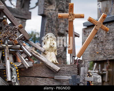 Statuette eines kleinen Mädchens durch hölzerne Kreuze umgeben Stockfoto