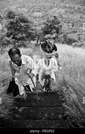 Balinesische DEVOTEES Treppen zu einem remote Hindu Tempel auf einem Hügel oberhalb einer Landwirtschaft Tal in der Nähe von pemuteran - Bali, Indonesien Stockfoto