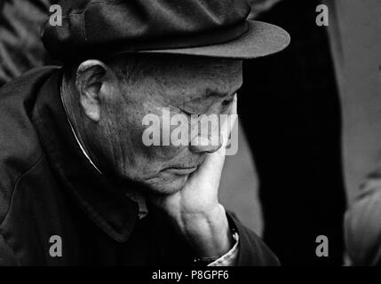 Ein chinesischer Mann konzentriert sich als er spielt ein Spiel des Chinese Checkers in Kunming, Yunnan, China Stockfoto