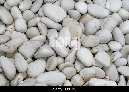 Stapel der Weiße, runde Steine durch einen getrockneten River Bank Stockfoto