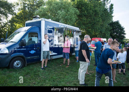 Oldtimer Hot Dog Van Essen Essen draußen Getränke Essen Hunger Burger Fahrzeug Leute treffen treffen Catering Kantine Männer Jungen reden wartenden Baum Stockfoto