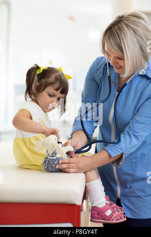 Arzt Untersuchung Spielzeug und kleine Mädchen mit Stethoskop Stockfoto