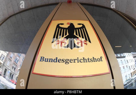 12. Juli 2018, Deutschland, Karlsruhe: ein Schild mit Bundesadler und das Logo der Bundesgerichtshof (BGH), der BGH mit einem Fish-eye Objektiv fotografiert. Die dritte der Senat hat das Urteil in Bezug auf die Frage, ob Eltern den Zugang zu den Facebook Account ihrer verstorbenen Tochter erlaubt sind. Dem Urteil zufolge müssen die Eltern als Erben müssen Zugriff auf die Facebook-Konto ihrer verstorbenen Tochter, die seit fünfeinhalb Jahren blockiert wurde, gewährt werden. Foto: Uli Deck / dpa Stockfoto