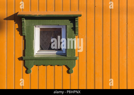 Rechteckiges Fenster in hellem gelb lackierten Holz Wand mit grünen Rahmen. Closeup Fragment von Haus außen Stockfoto