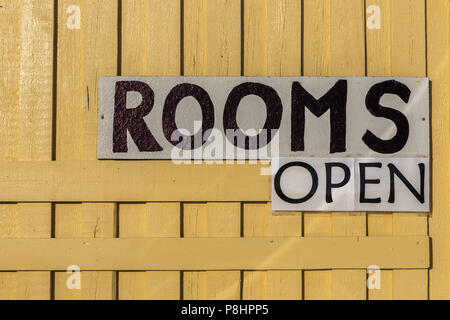 Handgefertigtes Schild mit Text' Zimmer öffnen' auf gelb Holz- strukturierten Hintergrund zeigt Unterkunft Vakanz Stockfoto