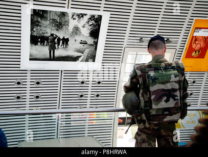 Avignon, Frankreich. TGV und Eurostar Bahnhof. Eine bewaffnete Soldaten auf Patrouille in der Station, die mit Fotos von Arles Fotografie eingerichtet ist f Stockfoto