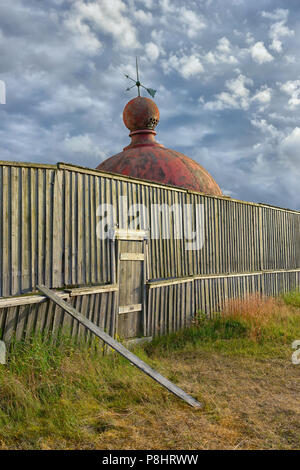 Kuppel von einem alten Leuchtturm hinter einer Holzwand in der Nähe von der Ostsee in den Dünen vor dem Hintergrund der trübe Sommer sky Stockfoto