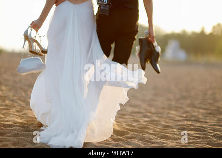 Glückliche Braut und Bräutigam am schönen Strand bei Sonnenuntergang Stockfoto