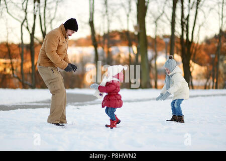 Junger Vater und seine beiden Töchter im Winter Spaß Tag Stockfoto