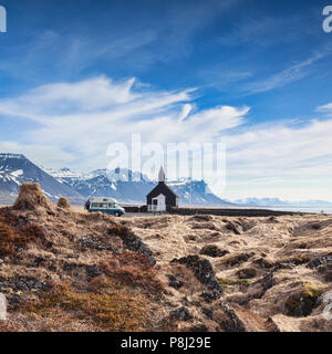 16. April 2018: Budir, Halbinsel Snaefellsnes, West Island - Die Schwarze Kirche und ein Volkswagen Wohnmobil mit Fahrrädern auf der Rückseite, mit Moos bedeckt... Stockfoto