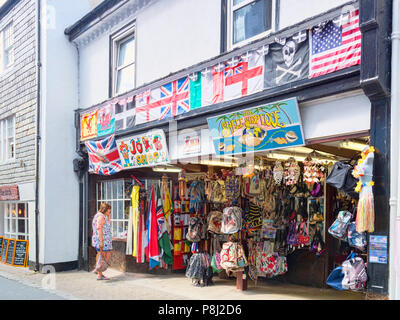 Vom 6. Juni 2018: Looe, Cornwall, UK-Geschäfte im Buller Straße, mit einem Witz Shop und eine Shell Shop. Frau Suchen in Fenster. Stockfoto