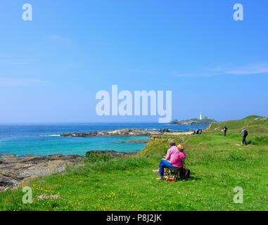 Ein Paar genießt die Aussicht auf godrevy Point, Gwithian, Heritage Coast Godrevy, Cornwall, England, Großbritannien Stockfoto