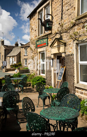 Das VEREINIGTE KÖNIGREICH, England, Yorkshire, Swaledale, Muker, Hauptstraße, Tische und Stühle draußen Kaffee Shop im Sonnenschein Stockfoto