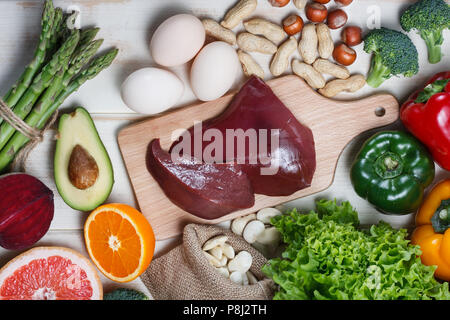 Natürliche Quellen von folsäure wie Leber, Spargel, Brokkoli, Eier, Salat, Avocado, Paprika, Muttern, orange, rote Bete und Bohnen Stockfoto