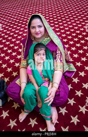 Stellen Porträt einer Frau und ihrer Tochter an einer Zeremonie im Tempel in der Sikh Gesellschaft in Richmond Hill, Queens, New York City. Stockfoto