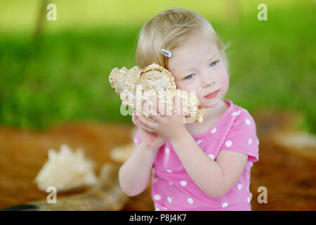 Süße kleine kleinkind Mädchen mit einer Shell auf Sommer Tag Stockfoto