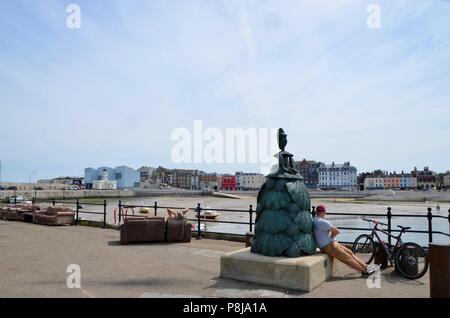 Radfahrer Mann sitzt auf Hafen mit Blick auf margate Kent uk Stockfoto