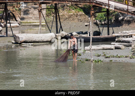 Morrelganj, Bangladesh, 27. Februar 2017: Fischer wirft einen Net am Ufer, um Fische zu fangen. Stockfoto