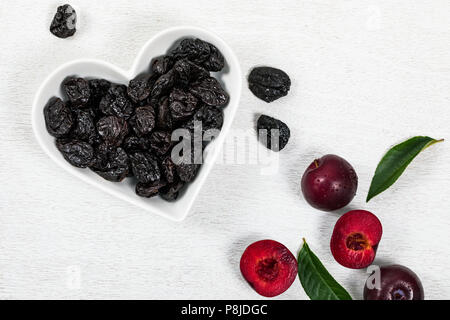 Getrocknete Pflaumen entsteint Pflaumen in Herzform Schüssel Hintergrund Stockfoto