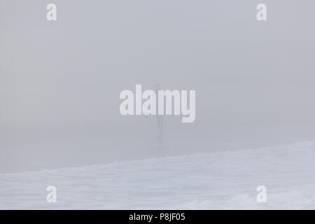 DEAL, NEW JERSEY - April 28, 2018: ein Surfer am Strand spazieren auf einem sehr neblig Frühling Morgen Stockfoto