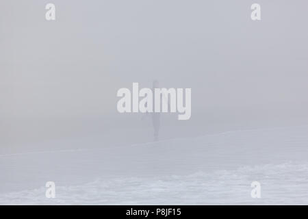 DEAL, NEW JERSEY - April 28, 2018: ein Surfer am Strand spazieren auf einem sehr neblig Frühling Morgen Stockfoto